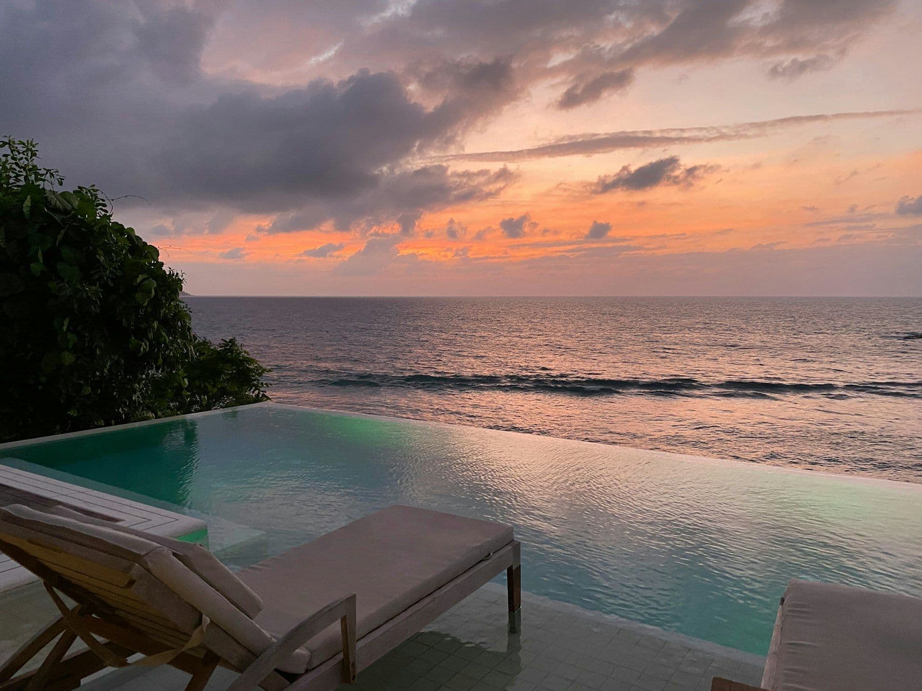 Illustrative image: infinity pool and loungers at sunset