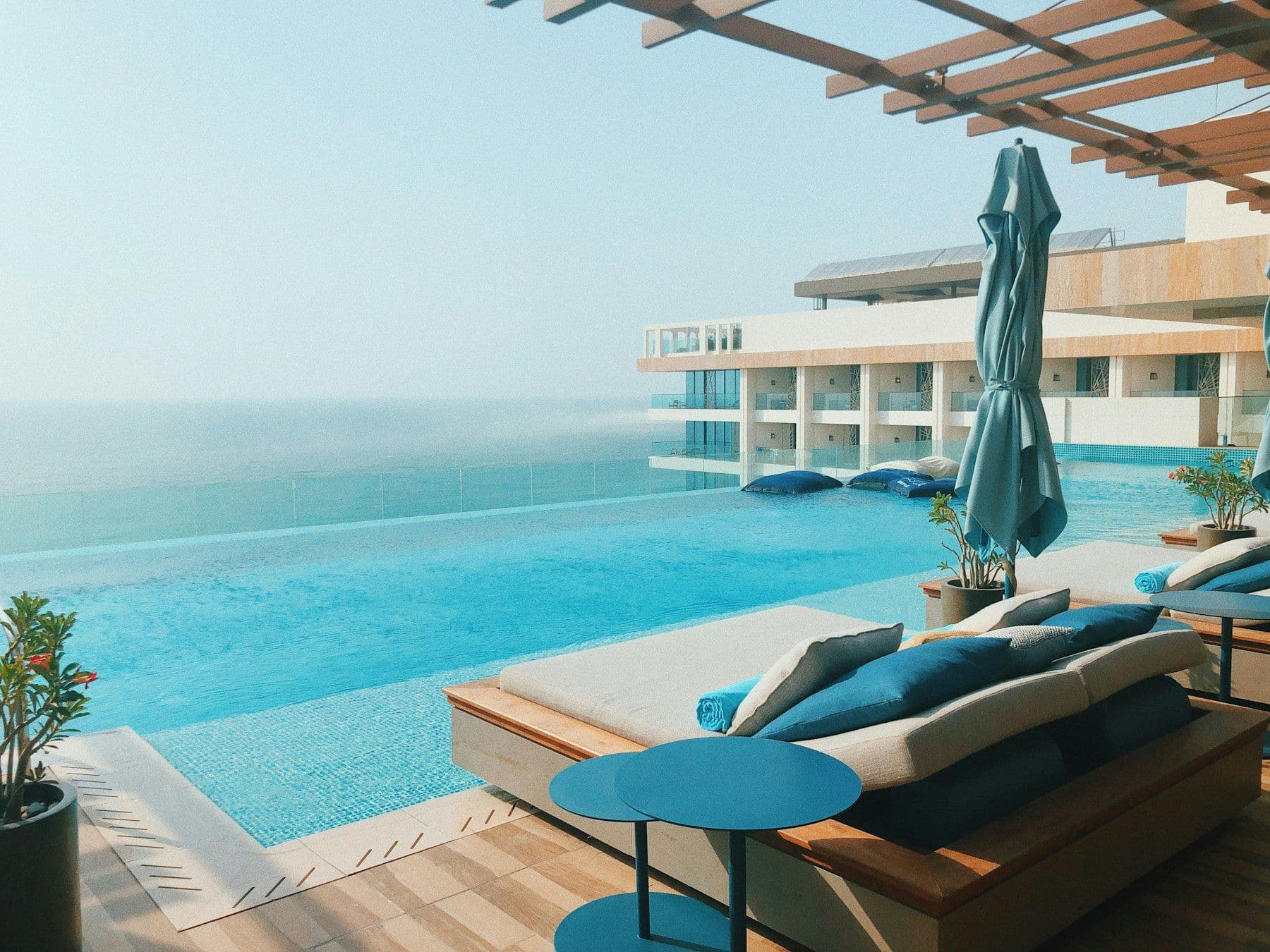 Illustrative image: pool terrace with cushioned loungers overlooking the sea
